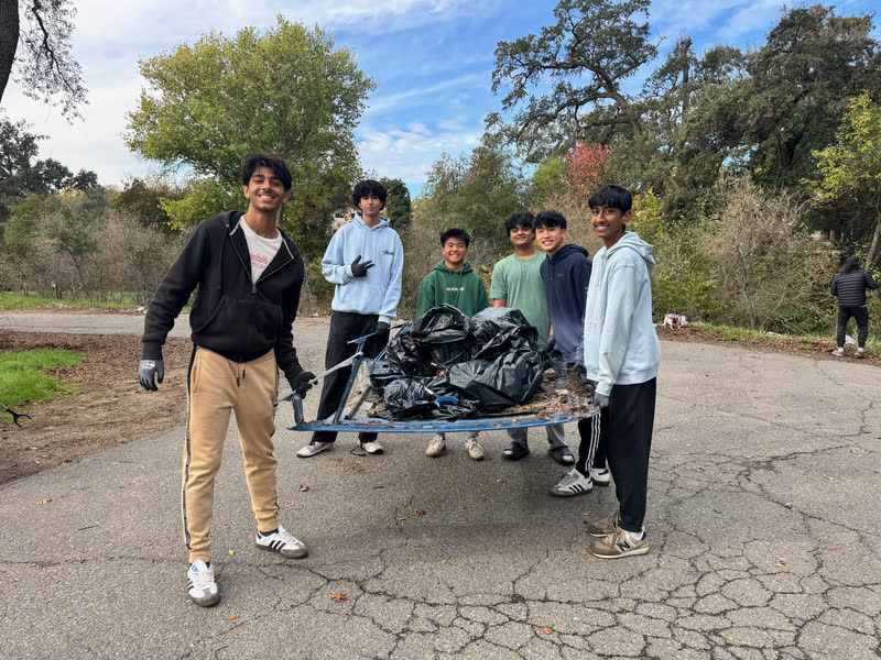 Friends carrying trash bags during a community cleanup