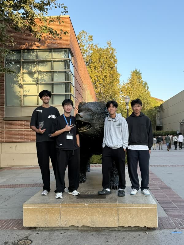 Four COSMOS students standing beside the UCLA Bruin statue