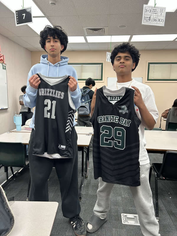 Two Granite Bay volleyball players holding each other's numbered jerseys