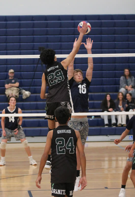 Granite Bay volleyball player number 29 reaching over the net to spike