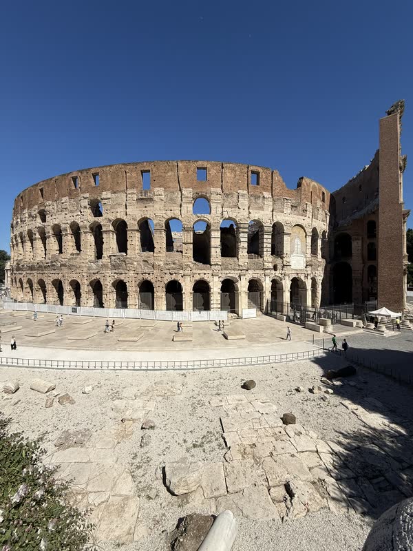The Colosseum in Rome beneath a deep blue sky