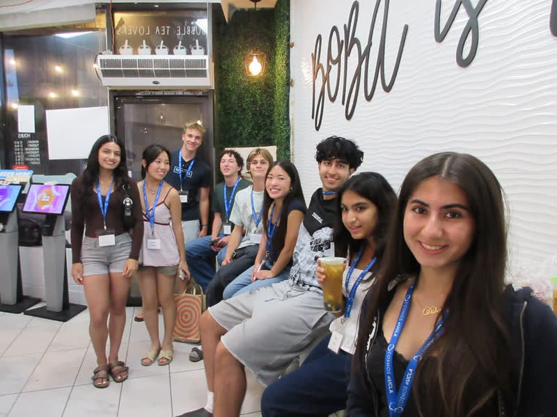 A group of students posing together inside a boba shop
