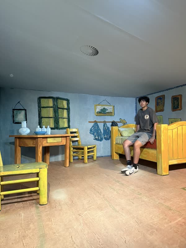 Pranil sitting inside a life-size recreation of Van Gogh's bedroom at Madurodam